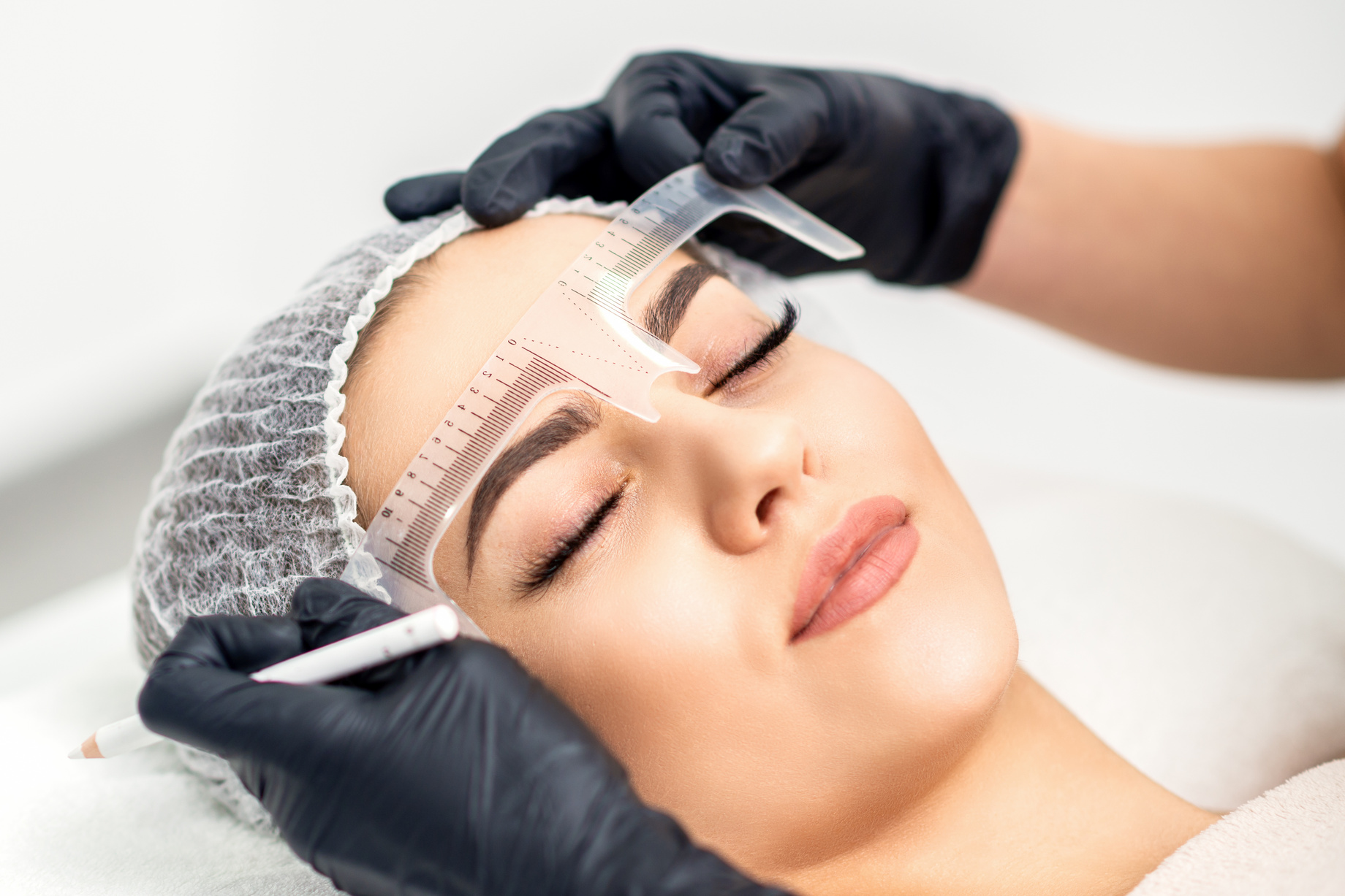 Beautician Measuring Brows with Ruler